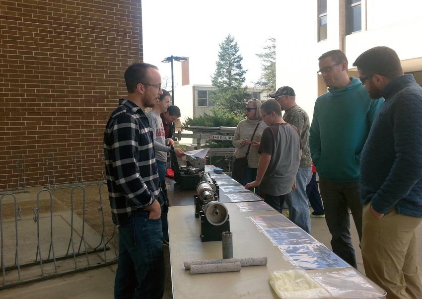 Visitors in Madison, Wisconsin, observe drill parts and photos as engineers answer questions during an April 2017 outreach event at UW-Madison