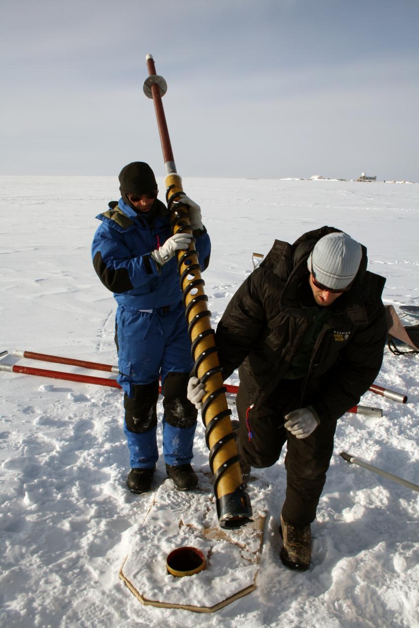 A scientist operates a PICO hand auger outside of Summit Station, Greenland