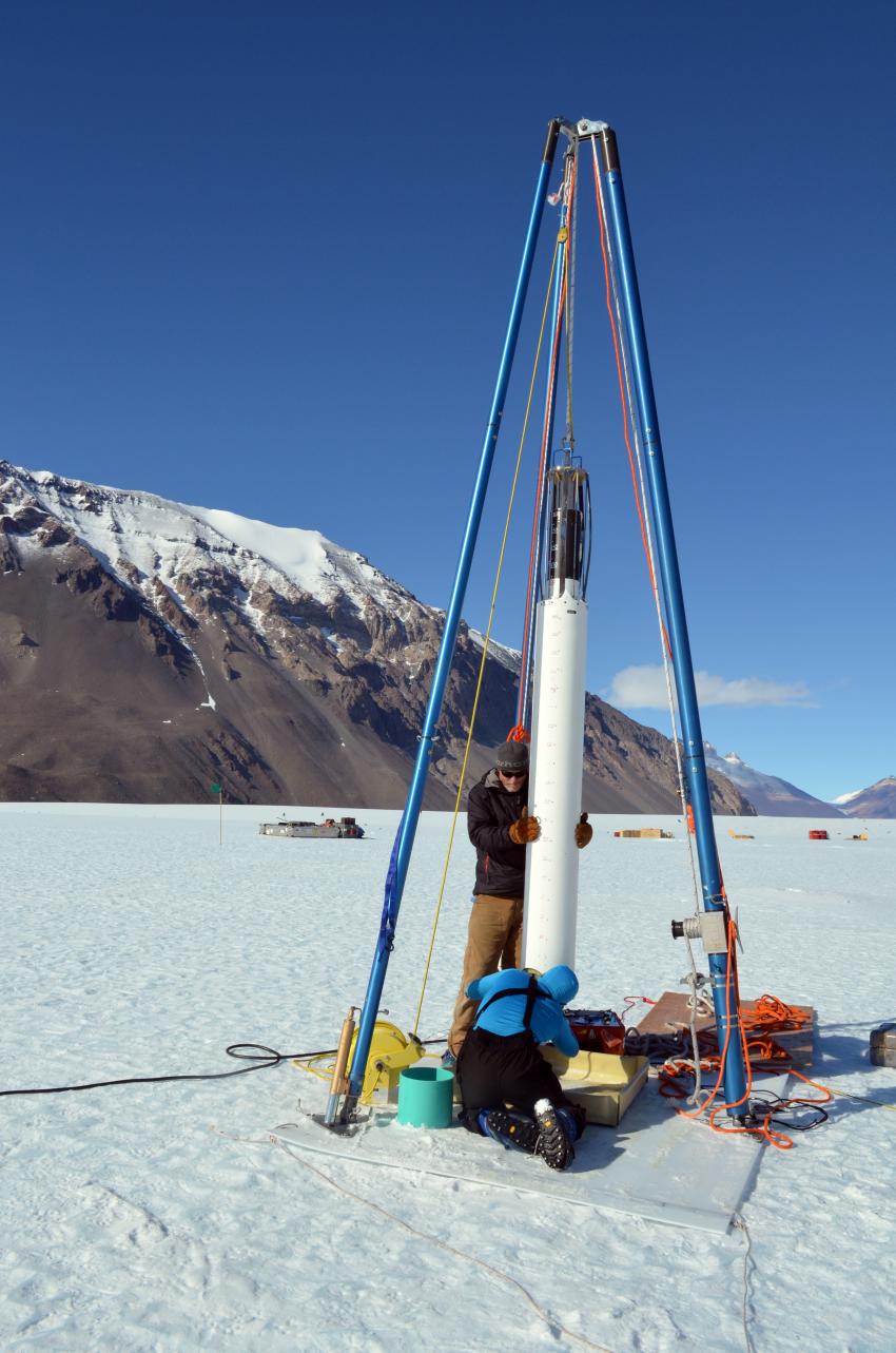 Scientist Michael Dyonisius, foreground, assists IDP driller Mike Jayred with drilling an ice core on Taylor Glacier, Antarctica