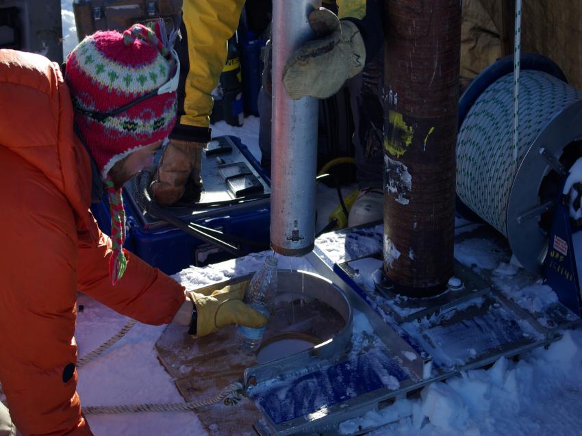 Collecting firn water from the drill head of the thermal drill during the 2013 field season in SE Greenland