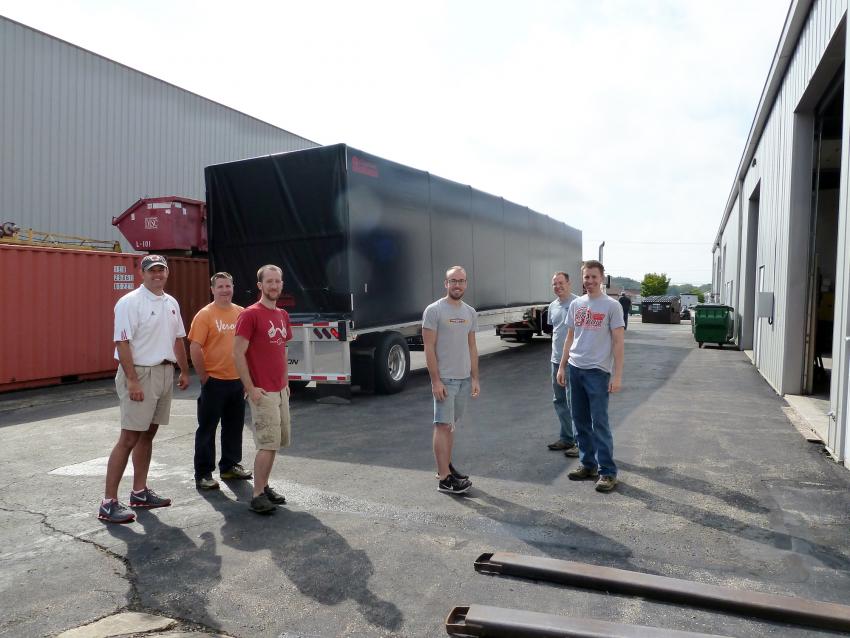 A happy IDDO team in front of the fully-loaded Conestoga trailer