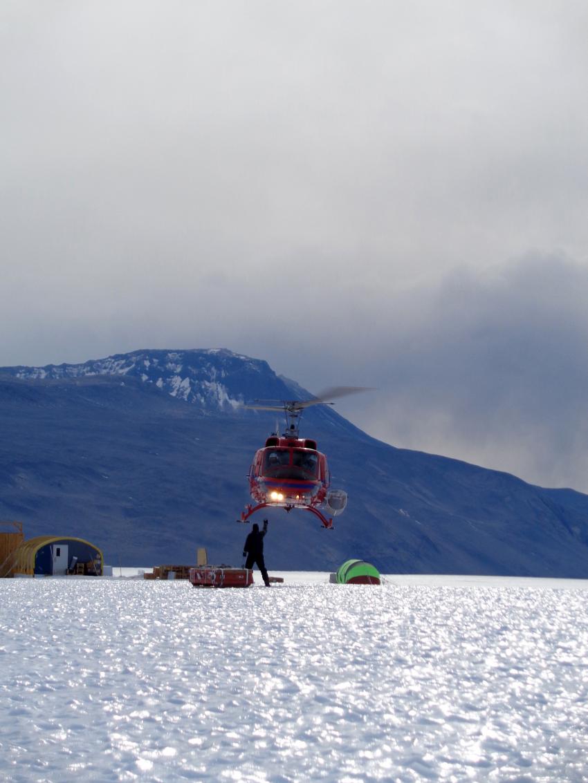Driller Mike Jayred attaches Blue Ice Drill cargo to a waiting helicopter at Taylor Glacier, Antarctica