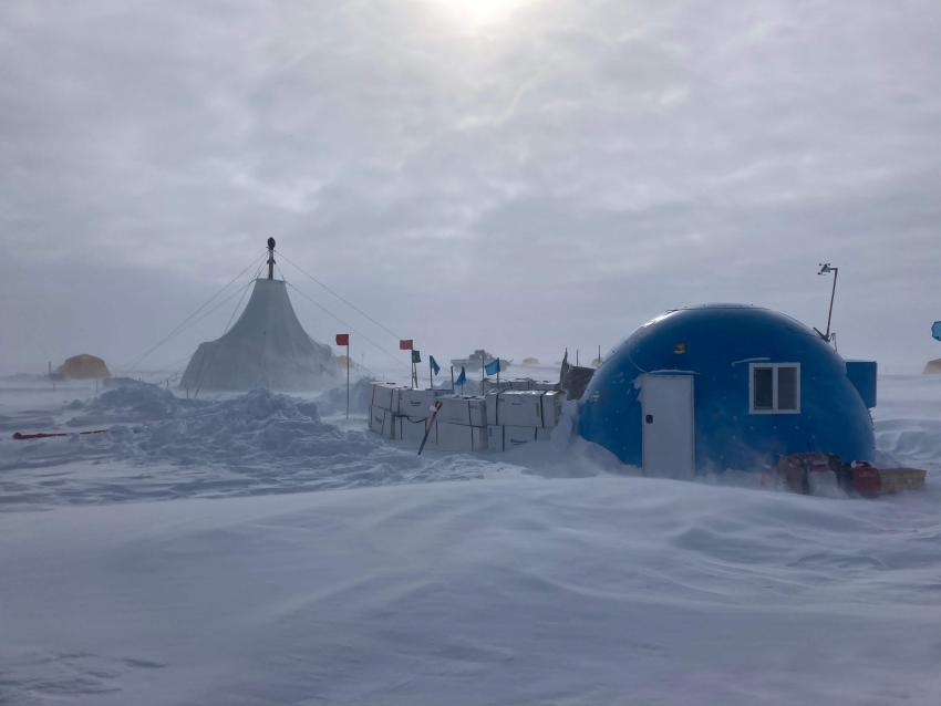 The Tunu, Greenland, field camp during the 2022 field season. The mast of the Foro 400 Drill can be seen protruding from the top of the white drill tent. Credit: Tanner Kuhl