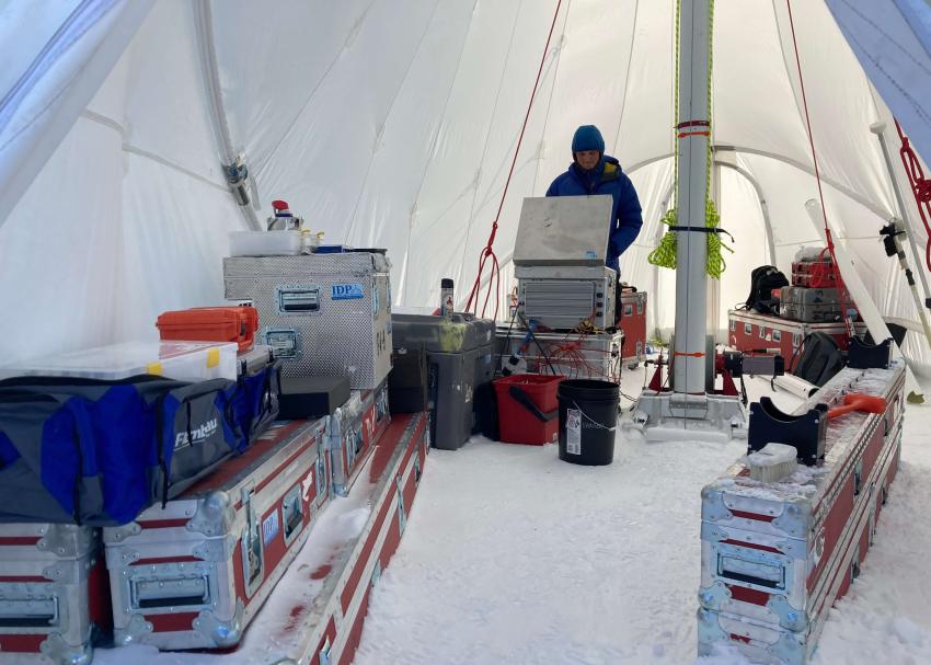 The inside of the MAST drill tent during the 2022 field season at Tunu, Greenland, showing IDP engineer Elliot Moravec operating the Foro 400 Drill. Photo credit: Tanner Kuhl.